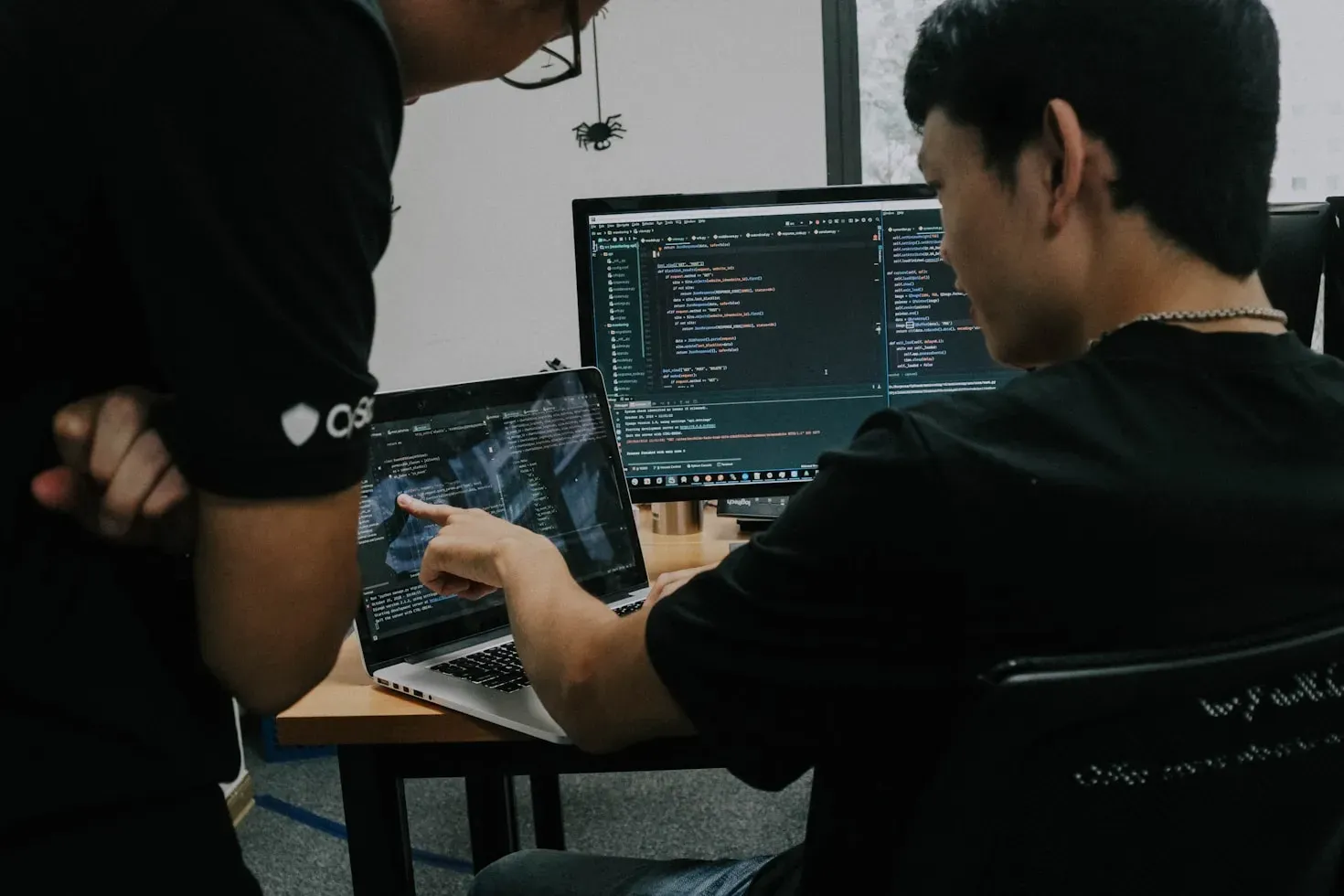 Two developers collaborating on code at their workstations